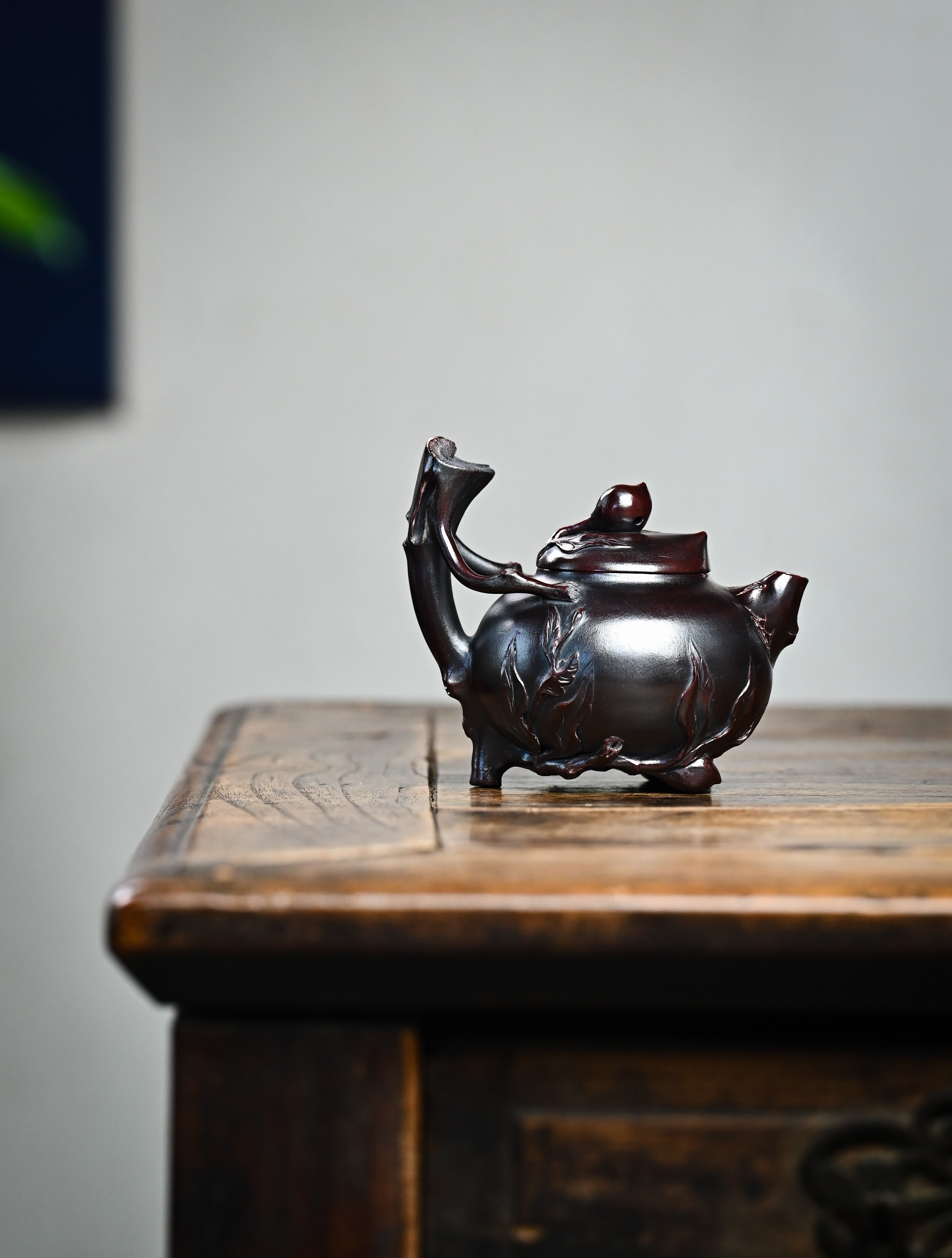YANYOO handmade Yixing teapot featuring aged Wuni clay and peach sculpture, lifestyle wide-angle right side.