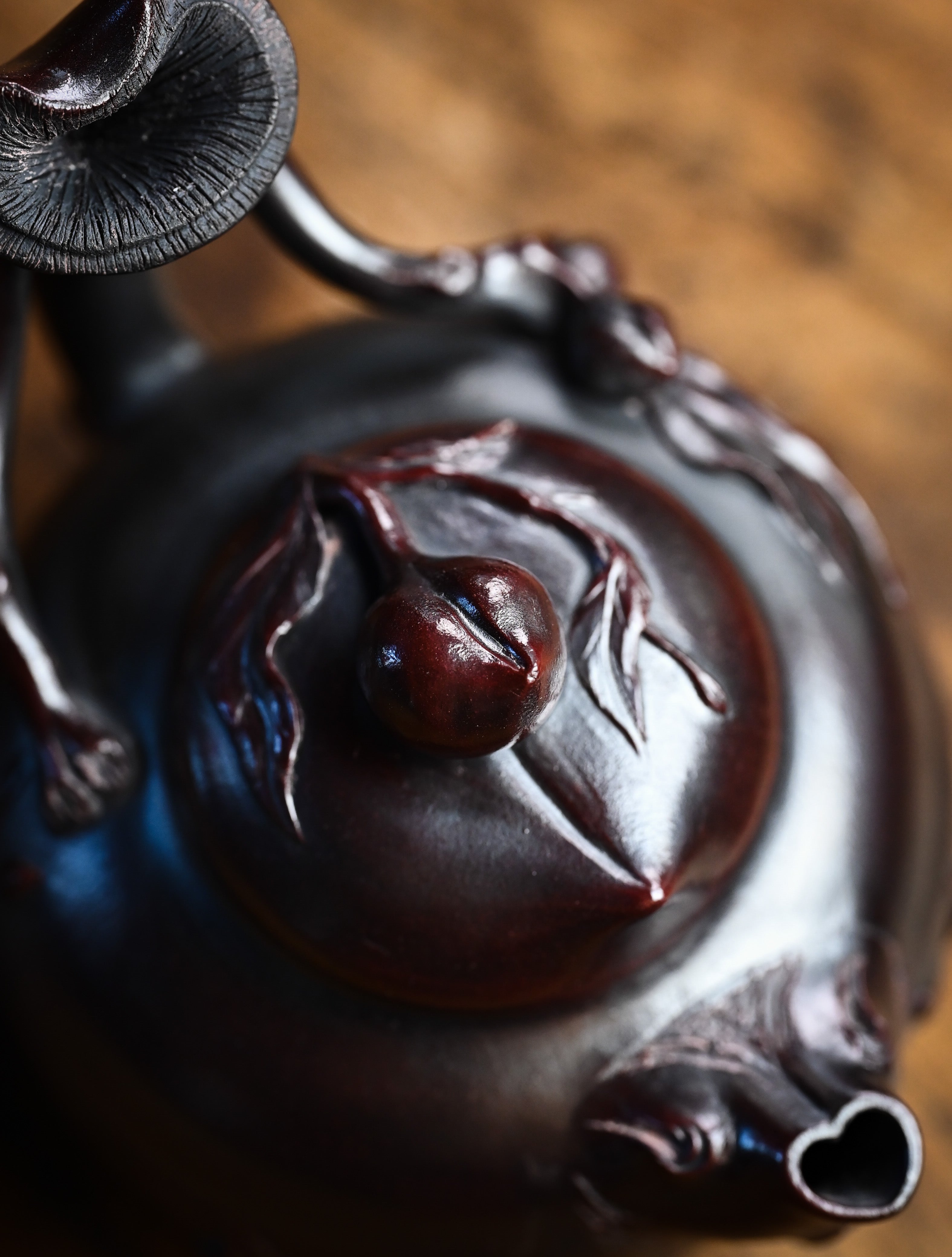 YANYOO handmade Yixing teapot featuring aged Wuni clay and peach sculpture, lifestyle top side.