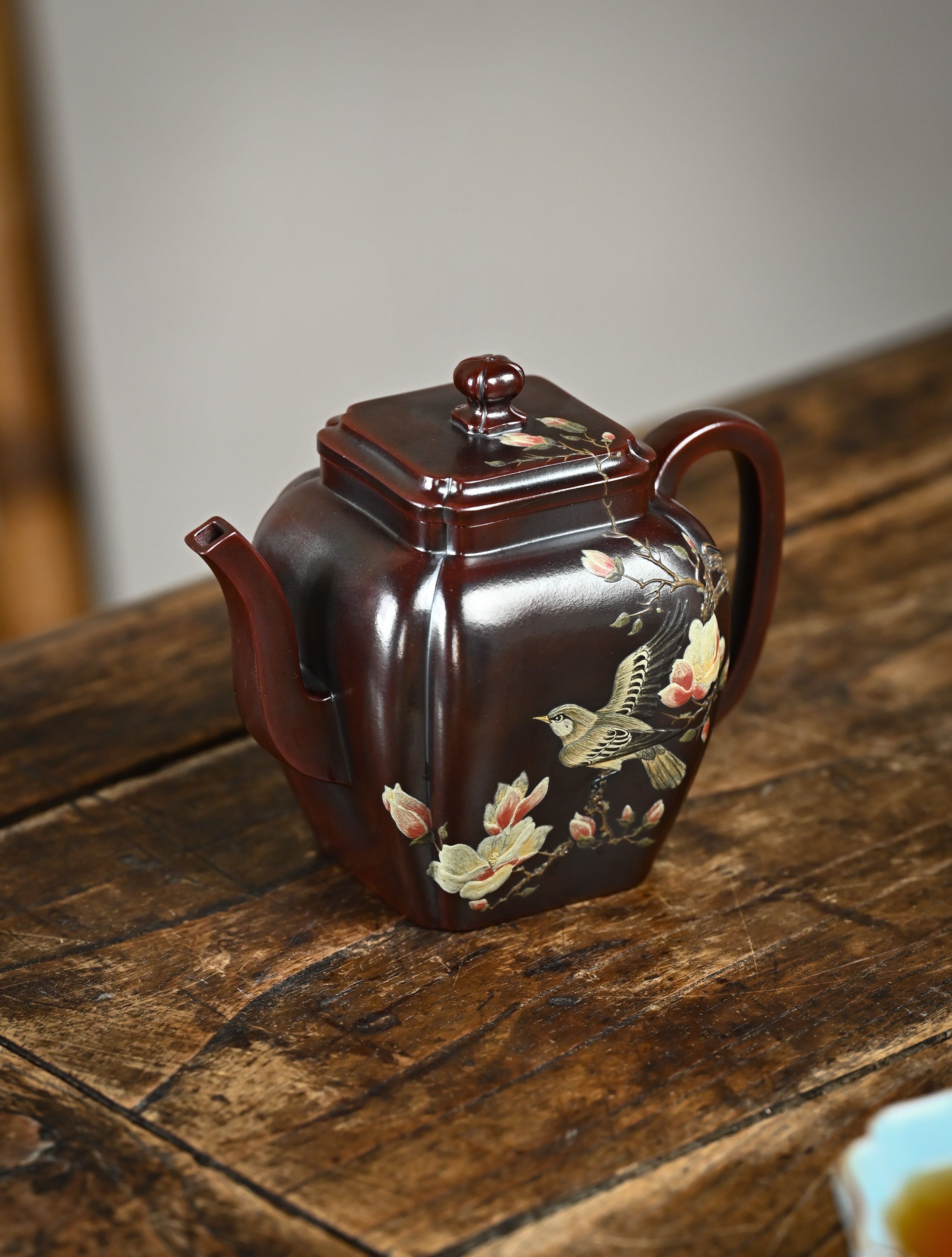 YANYOO handmade Yixing teapot featuring aged Wuni clay, bird-and-flower painting and a unique square shape, Ru Fang, lifestyle left side.