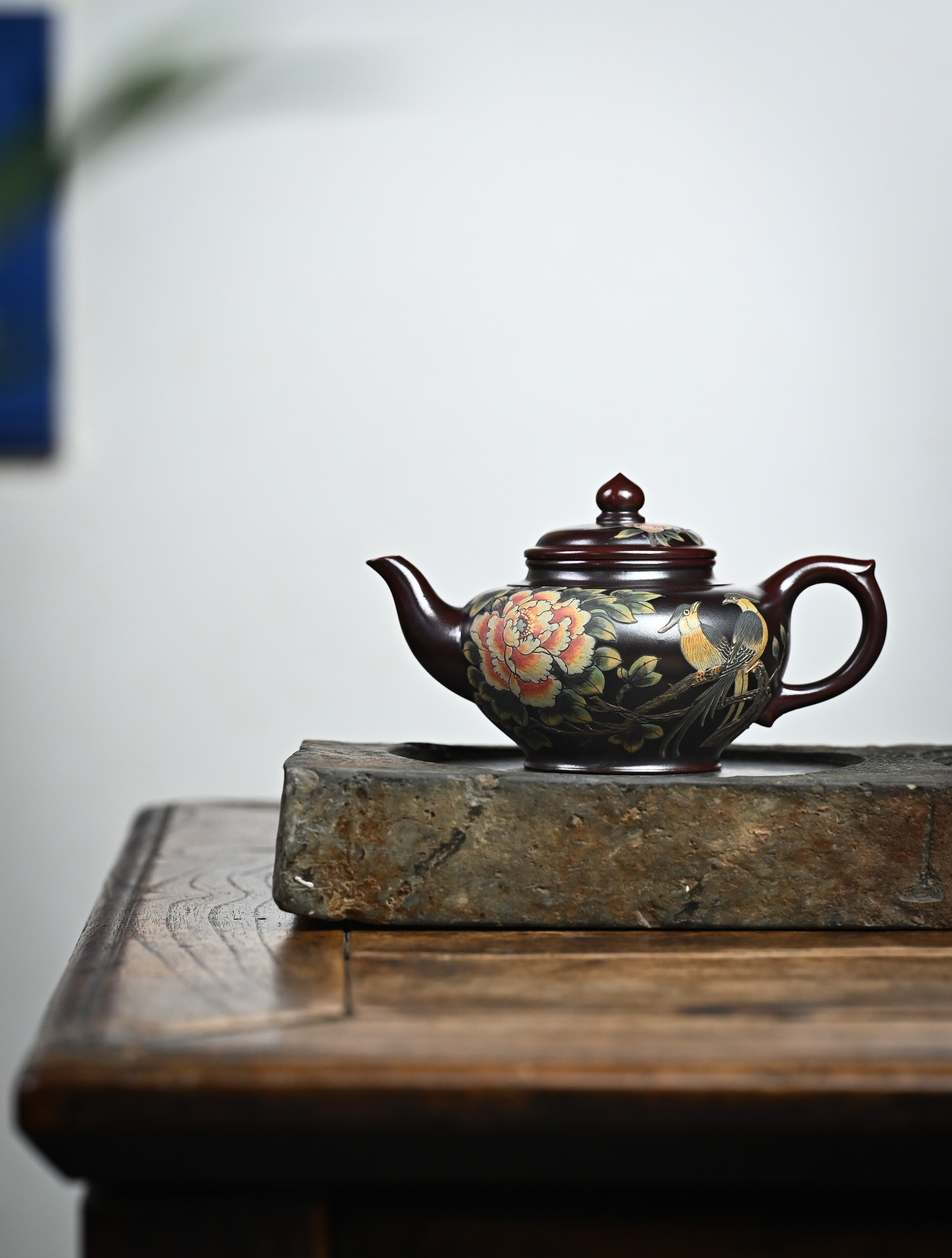 YANYOO handmade Yixing teapot featuring aged Wuni clay and bird-and-flower painting, lifestyle wide-angle left side.
