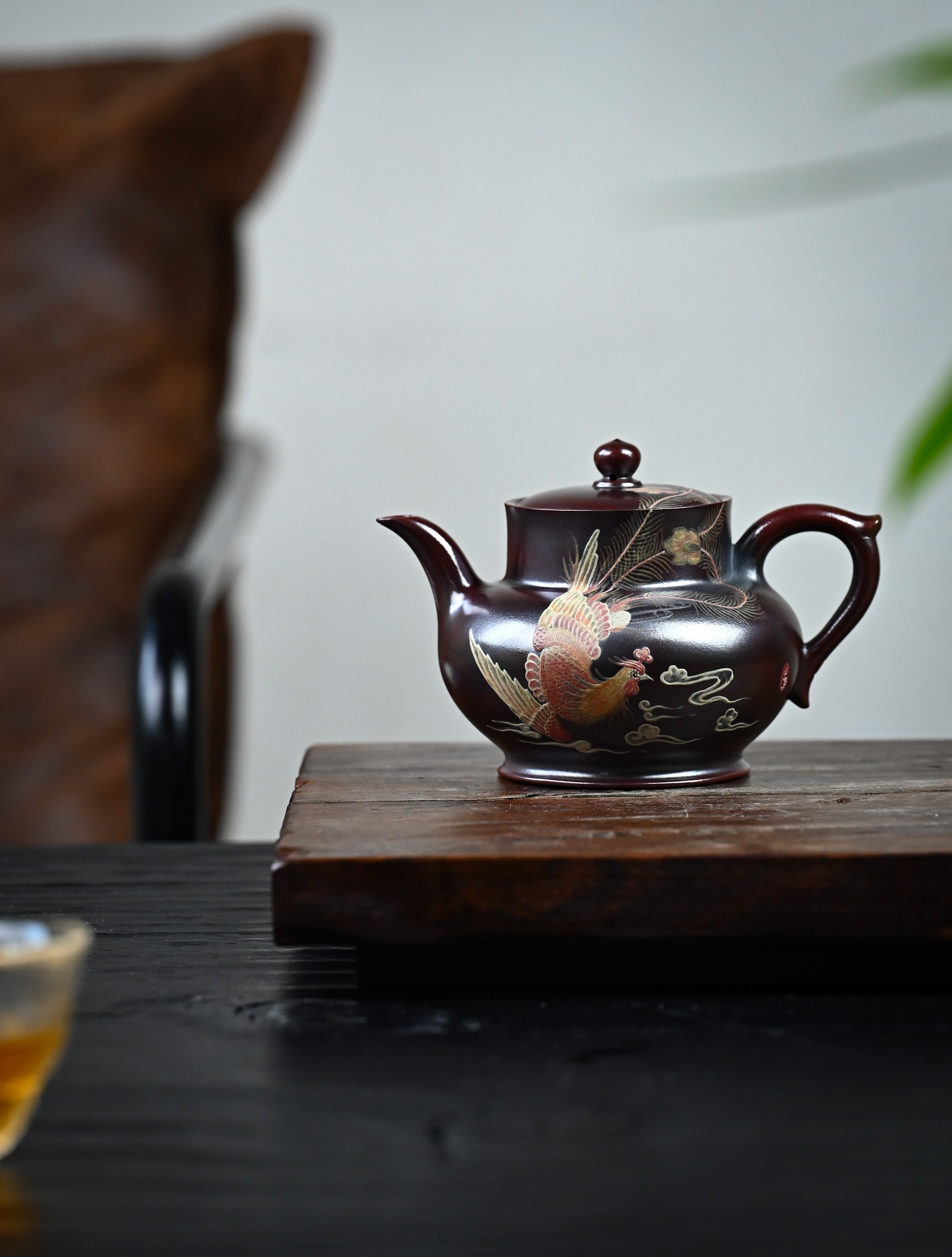 YANYOO handmade Yixing teapot featuring aged Wuni clay and phoenix-and-cloud painting, lifestyle wide-angle left side.