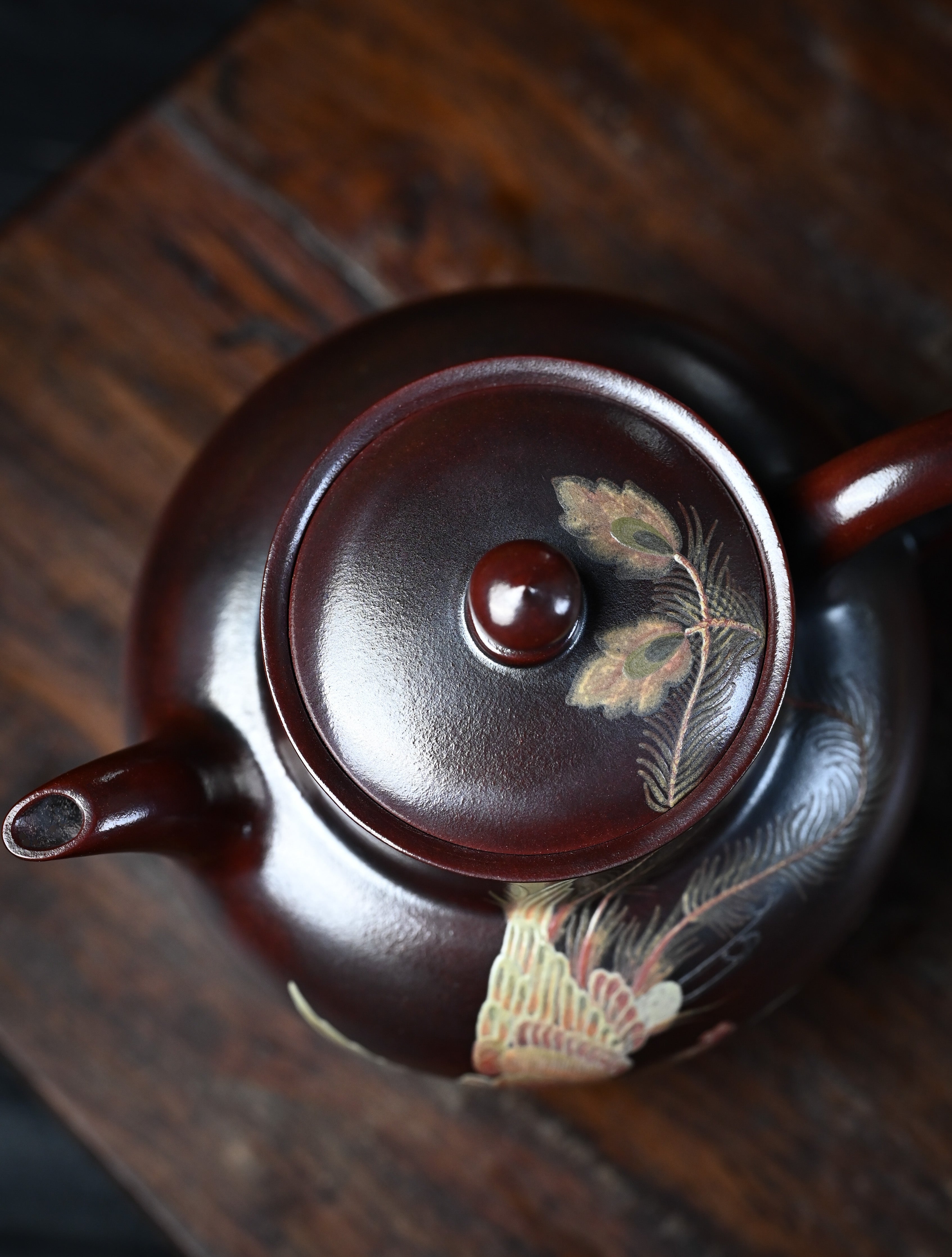 YANYOO handmade Yixing teapot featuring aged Wuni clay and phoenix-and-cloud painting, lifestyle top side.