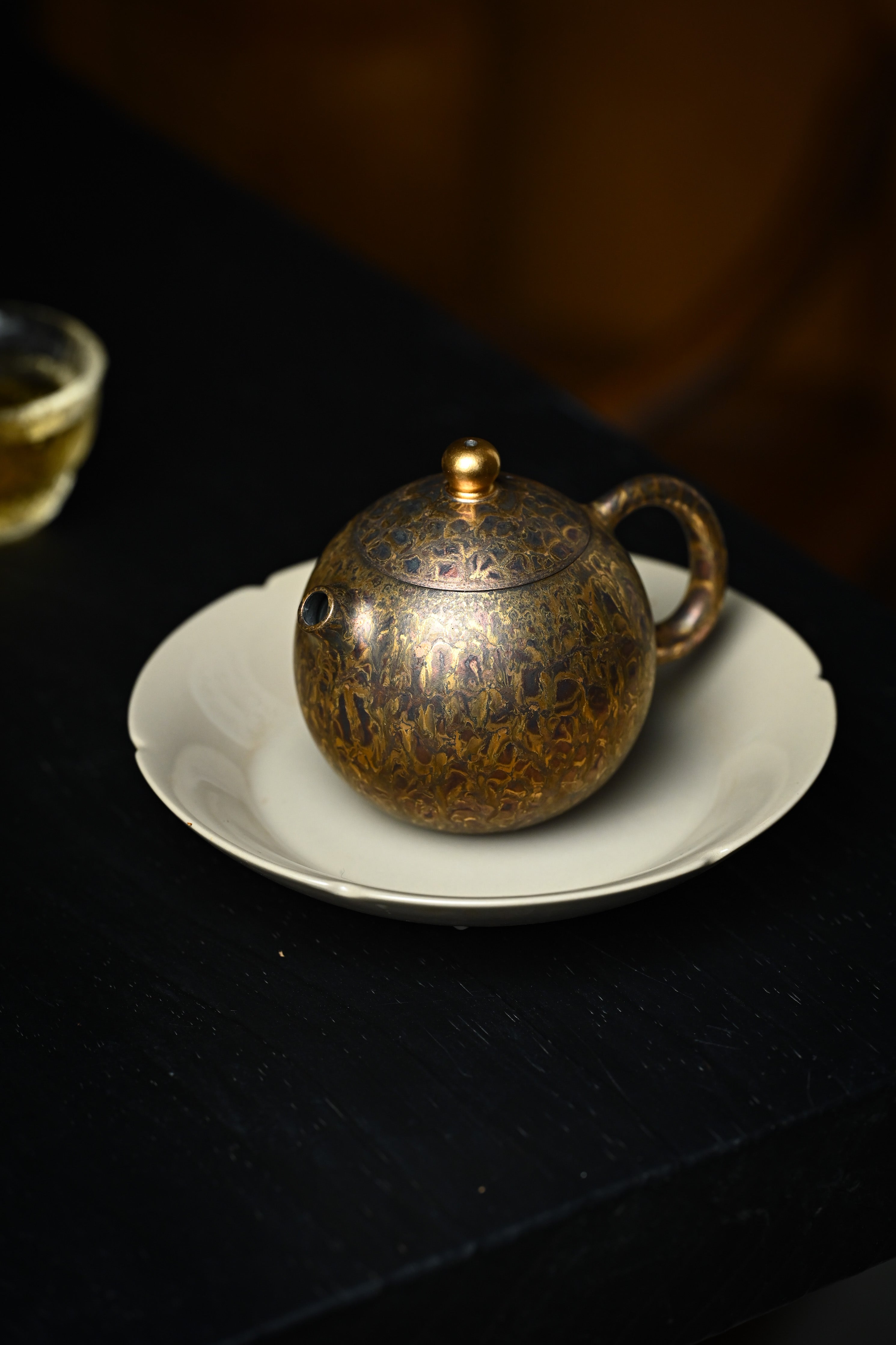 Handmade YANYOO Yixing teapot featuring Feather-Plume firing technique, Long Dan, lifestyle left side.