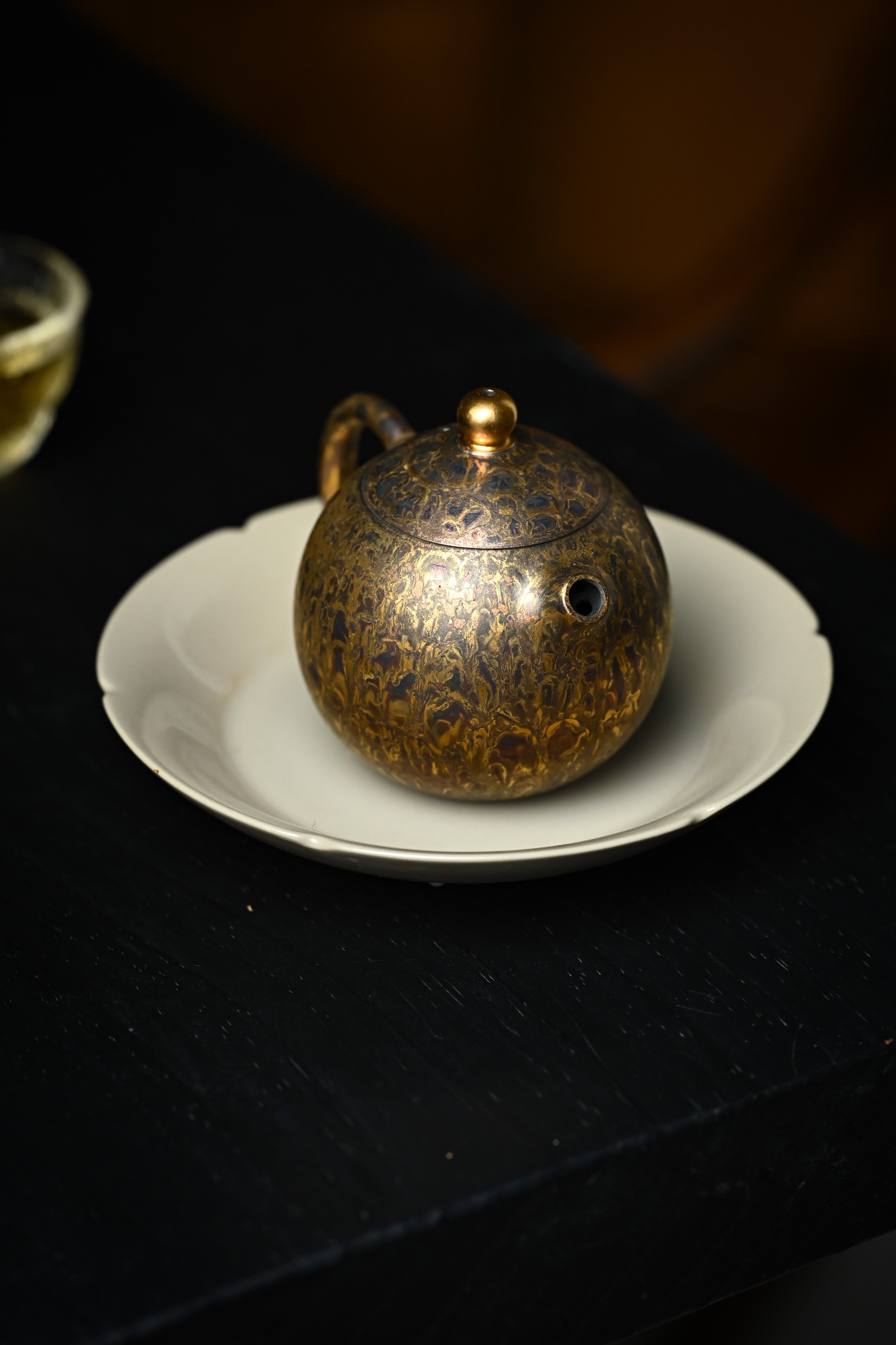 Handmade YANYOO Yixing teapot featuring Feather-Plume firing technique, Long Dan, lifestyle right side.